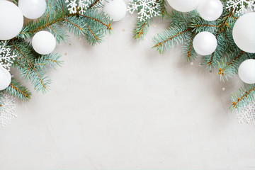 White Christmas background with Christmas tree branches, snowflakes and balls
