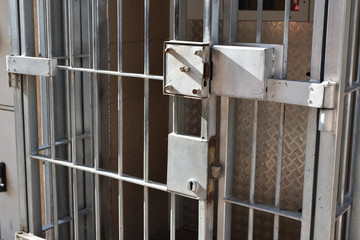 Closed prison door with a lock and gratings, closeup - 288555591