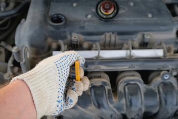checking the oil level in a car engine
