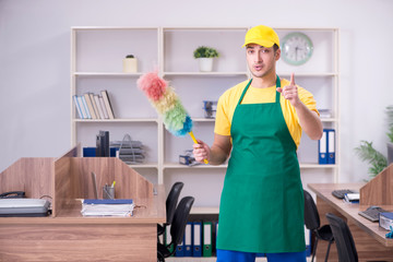 Young male contractor cleaning the office
