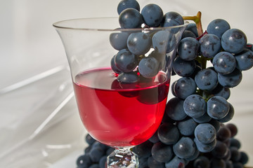 Red wine in wine glass with grapes.