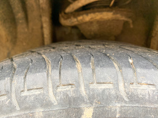 Close up of the tire of an dirty and used car wheel