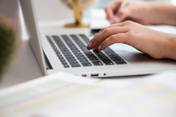 Typing hands of a schoolgirl and laptop close-up