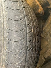 Close up view of the tire of an old damaged car wheel