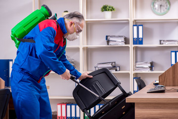 Old professional contractor doing pest control in the office