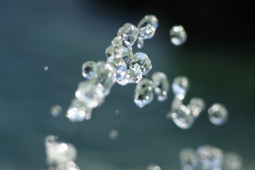 Glasklares Wasser spritzt aus einem Trinkwasser Brunnen, eingefroren wie Glasperlen 4