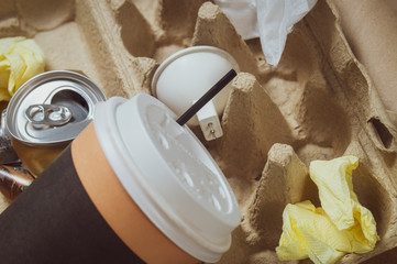 garbage Cup of coffee, egg cage, burnt out led lamp and other garbage close-up