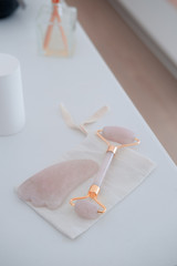 Rose quartz guasha stone and roller. Beauty anti-ageing concept. Top view