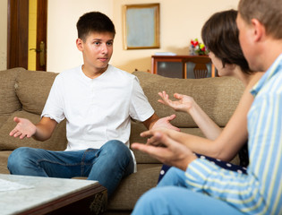 Angry parents quarrelling with his upset teenage son at home