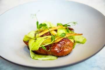 Baked quail with vegetables lying on a plate