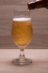 bottle pouring lager into glass