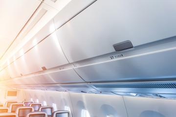 Shelf for hand luggage over the passenger seats in the airplane.