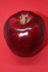 One Whole Red Delicious Apple on a Red Background