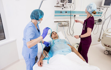 Doctors give resuscitation to a male patient in the emergency room. Cardiac massage