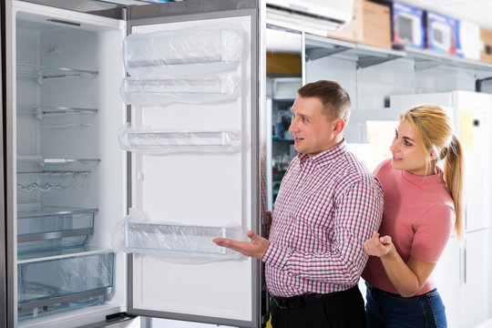 couple chooses refrigerator in shop