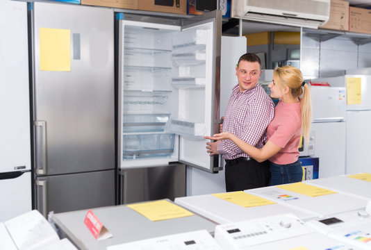 Family couple selecting new refrigerator in  appliances  store