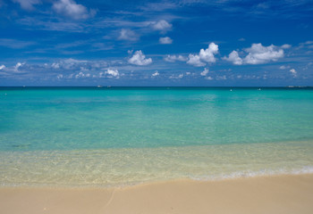 Fototapeta na wymiar Crystal clear waters and pinkish sands on empty seven mile beach on tropical carribean Grand Cayman Island