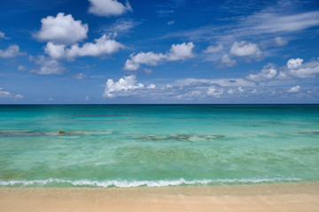 Crystal clear waters and pinkish sands on empty seven mile beach on tropical carribean Grand Cayman Island