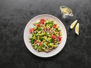 roasted romanesco salad on a black background, top view