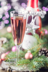 Pink champagne in a glass and christmas decorations