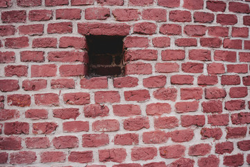 Fototapeta premium Echoes of war. Wall damaged by a military projectile (bomb), broken red brickwork. Brest fortress, exterior, fortification
