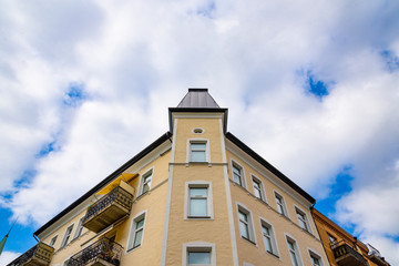 Dwelling house in Sweden. View of top corner of the house from the bottom stread road. Windows and balconies with awning