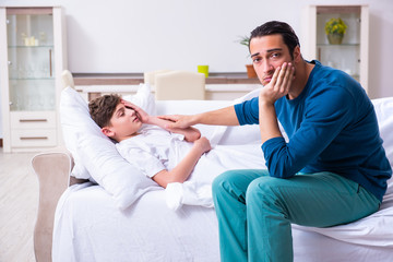 Obraz premium Young father caring for sick son