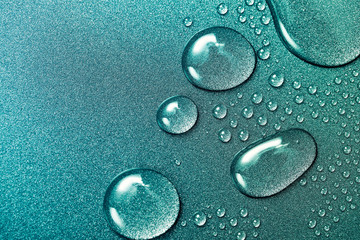 Water drops on shiny and grainy metal surface, abstract background with wet drops