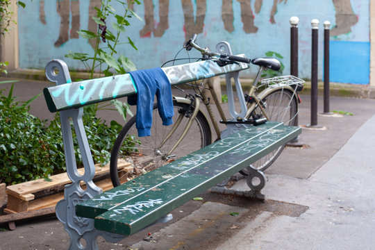 Bench with some left clothes ith a bike in Patis