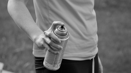 hand holding a spray can with torso