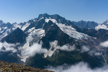Mountain peak in black, covered with glaciers and snow. Dombay, Russia