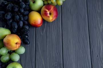 Background for an inscription with fruits. Apple, grape, nectarine on a gray wooden background. Fresh Vitamins in Food