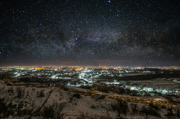 City at night against the background of the starry sky