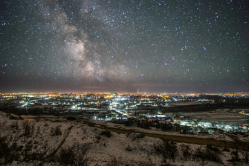 City at night against the background of the starry sky