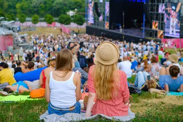 Gartenposter Couple is watching concert at open air music festival © Anton Gvozdikov