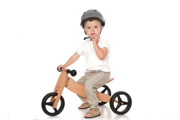 Little cute driver with helmet on his new bike isolated on white background.