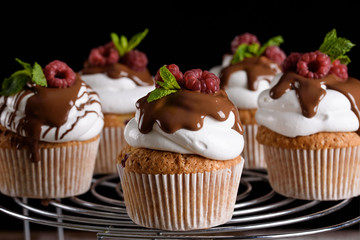 The process of making cupcakes, coating a cream from a pastry bag in the hands of a pastry chef.