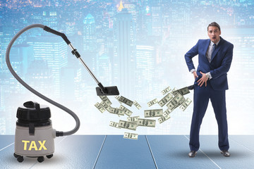 Businessman and vacuum cleaner sucking money out of him