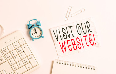 Writing note showing Visit Our Website. Business concept for visitor who arrives at web site and proceeds to browse Blank paper with copy space on the table with clock and pc keyboard