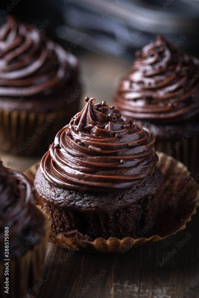 Sticker chocolate cupcake on dark wooden background