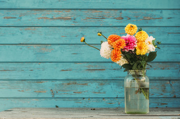 Fall flowers in glass jars standing on the table outside