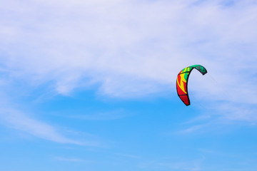 multi-colored kite flying in the blue sky