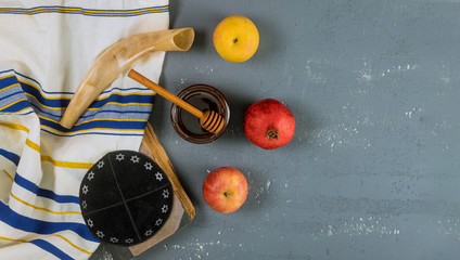 Shofar and tallit with glass honey jar and fresh ripe apples. Jewesh new year symbols. Rosh hashanah