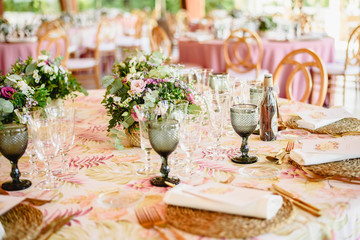 Elegant cutlery and floral arrangements for a table in a wedding restaurant with vintage style centerpieces.