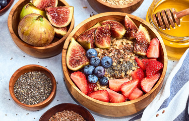 Healthy breakfast and breakfast ingredients, oatmeal with fruits and berries, figs, blueberries, strawberries, flax and chia seeds, honey. Top view, flat lay