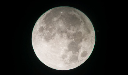Zoomed photo of the full Moon, isolated on a black sky