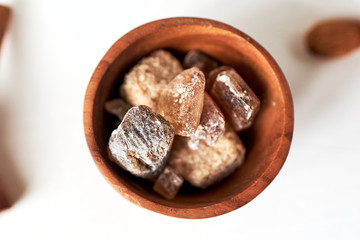 Brown cane sugar lump in a sugar bowl, top view. Concept diet, junk food, health.