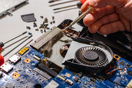 The master repairs the laptop from overheating