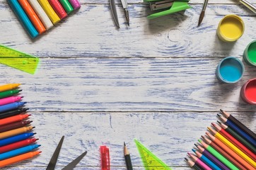 Creative concept with school supplies. Frame with school accessories and a wooden background.