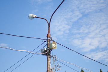 Lamppost against the blue sky. Wires supplying electricity to city lighting.